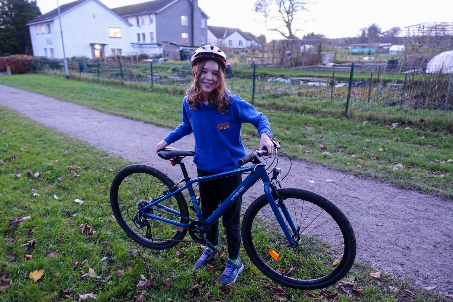 Best 26" kids' bikes: girl in a blue hoodie lifting the Blue Riverside 900