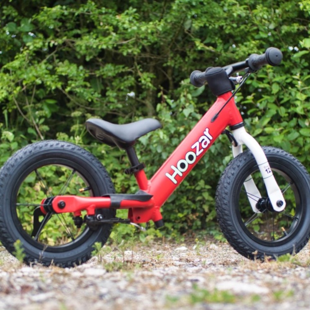 Best balance bikes: A Hoozar Cruz 12 photographed on gravel in front of a bush