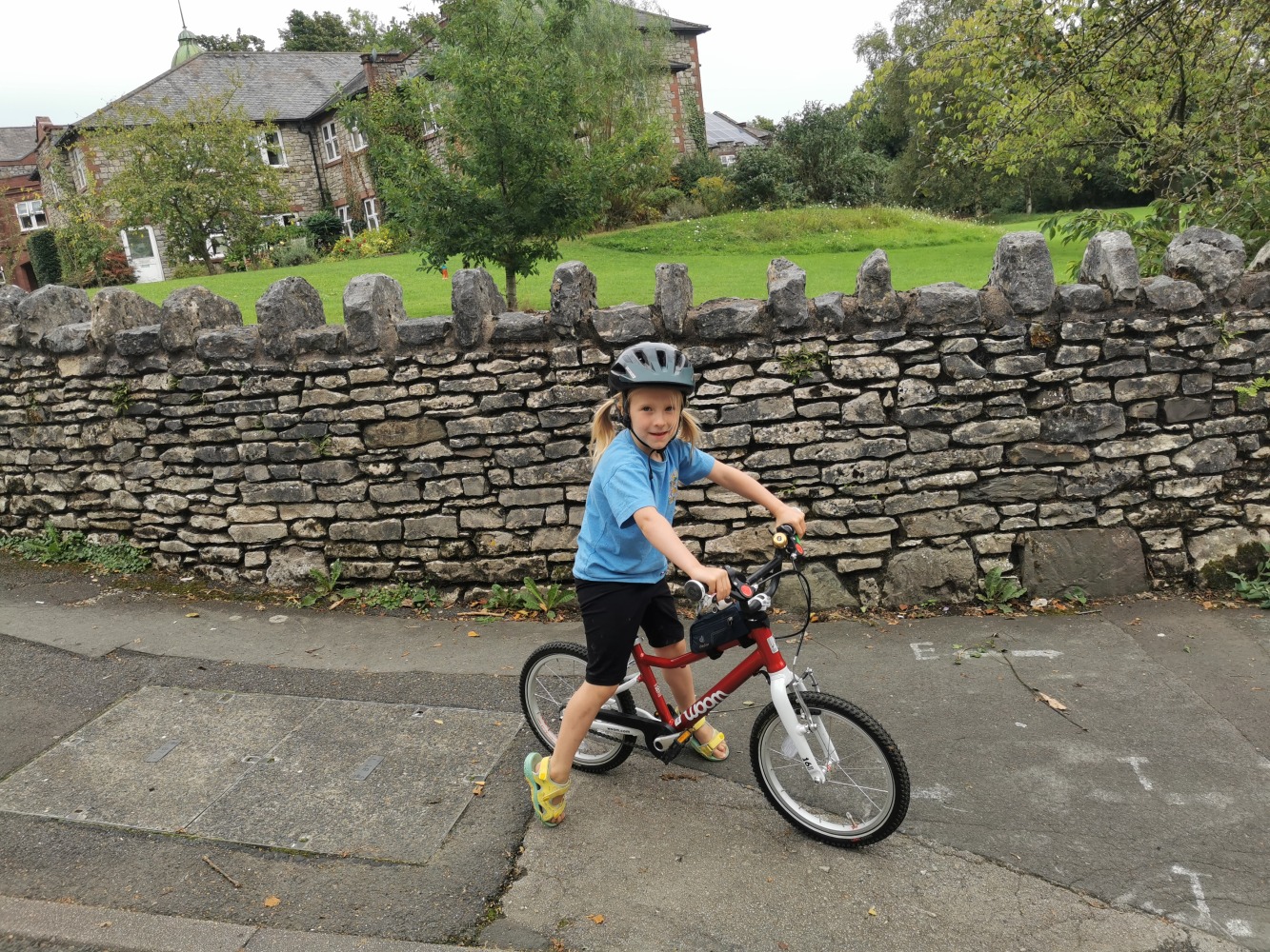 Girl with pig tails on a red woom bike