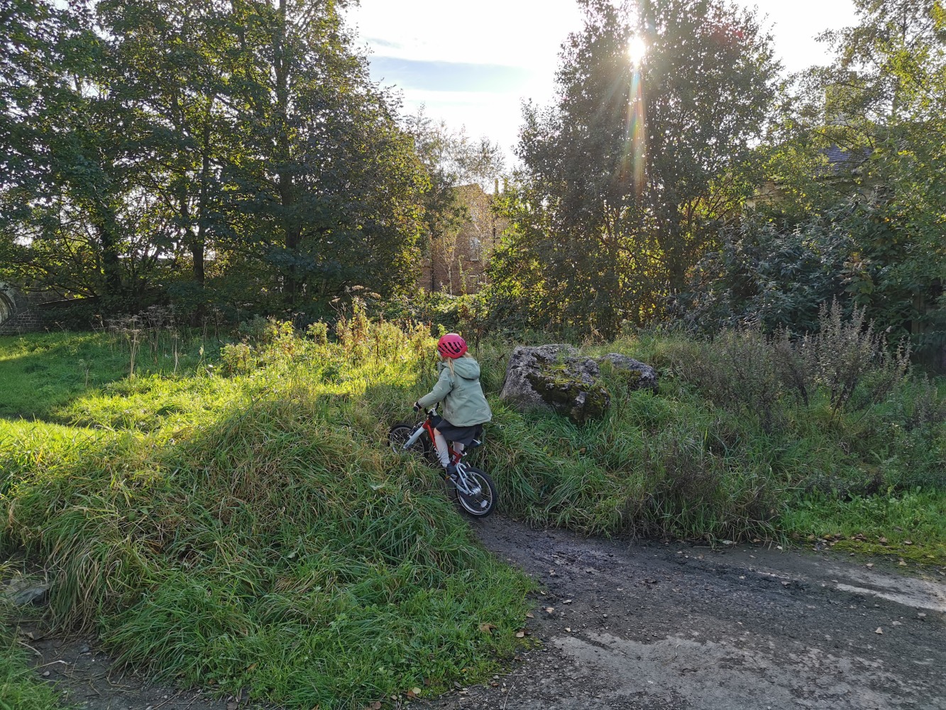 girl riding her red bike on a muddy hill