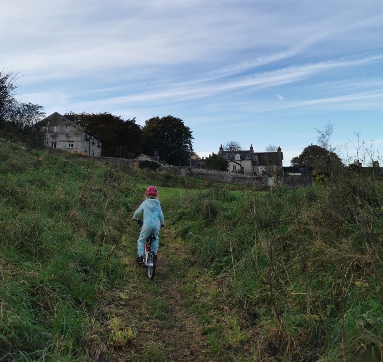 girl riding a bike in a blue fluffy onesie