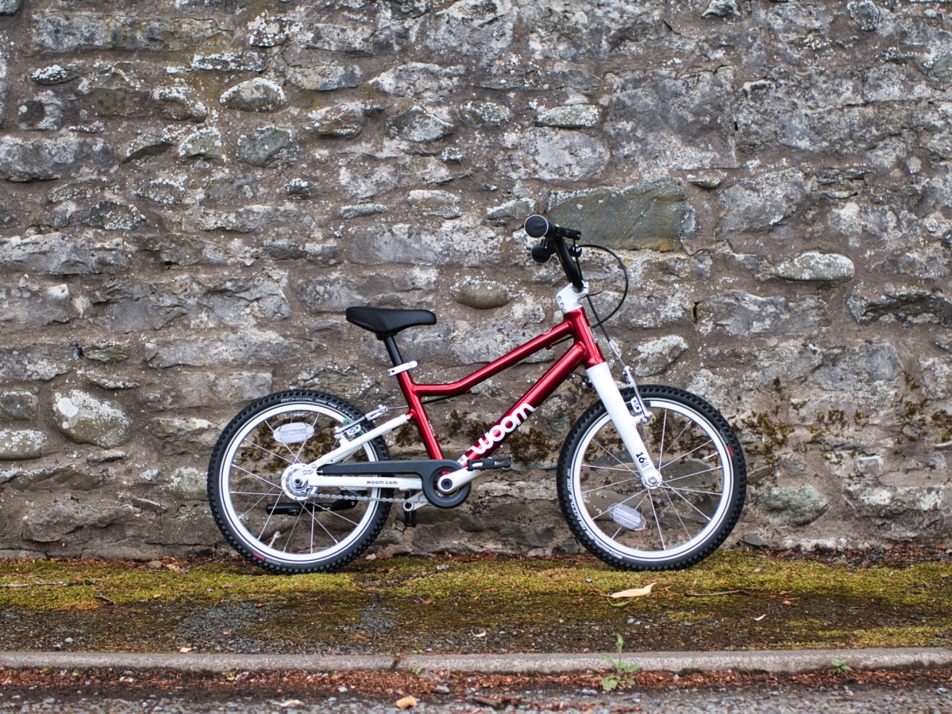 red bike against a stone wall