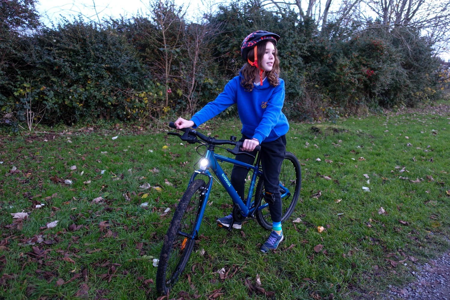 Girl riding the Blue Riverside 900, with the front light on