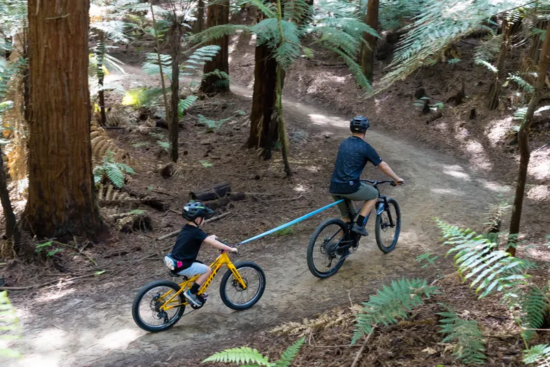 Child being towed up a trail with a shotgun tow rope