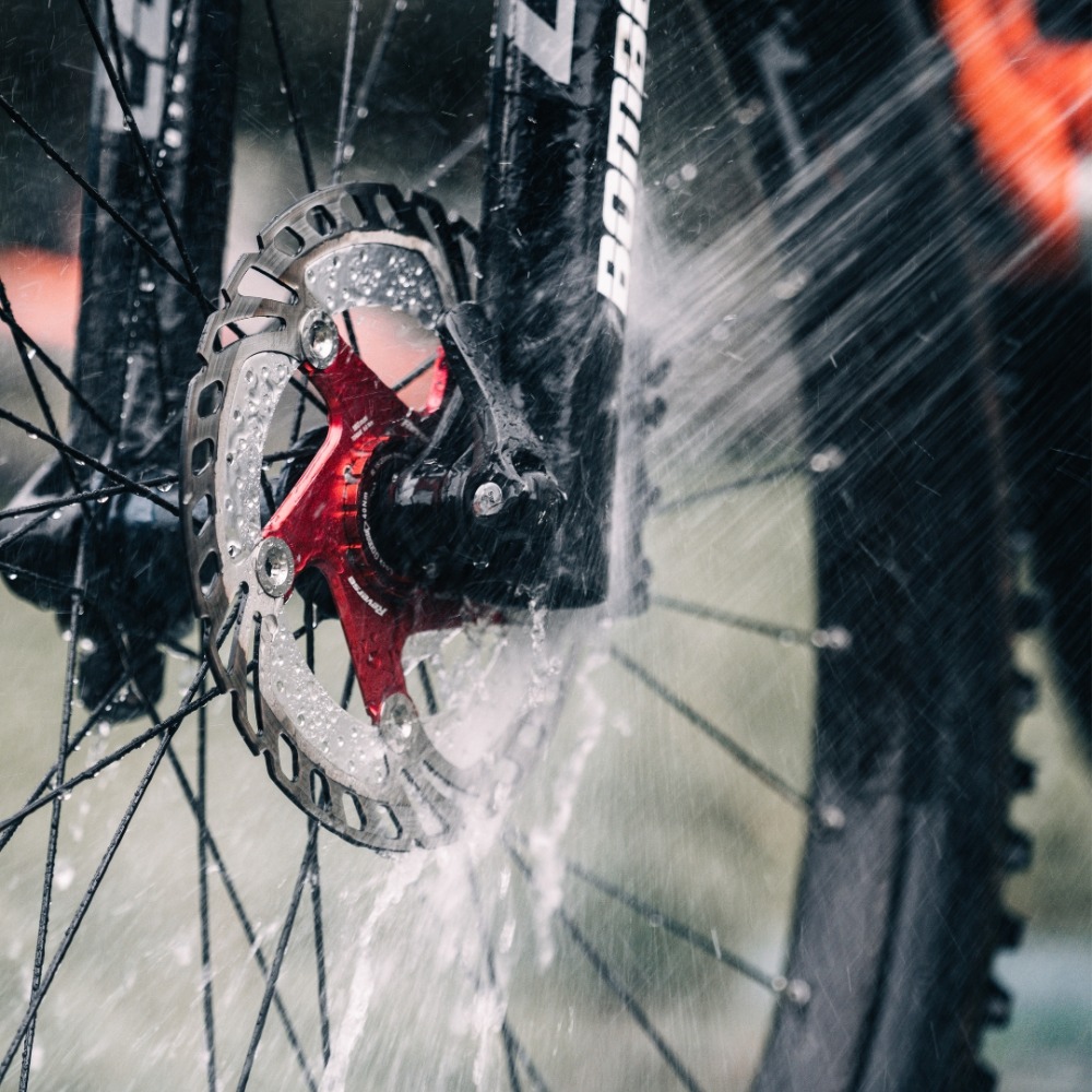 Winter cycling with kids: A close up of a disc brake rotor being sprayed with water