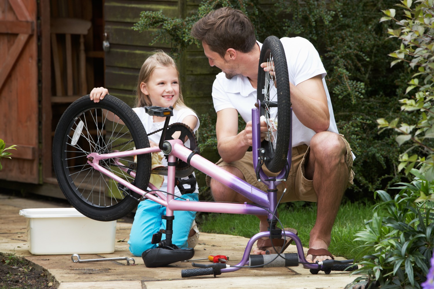 dad and daughter cleaning a kids bike