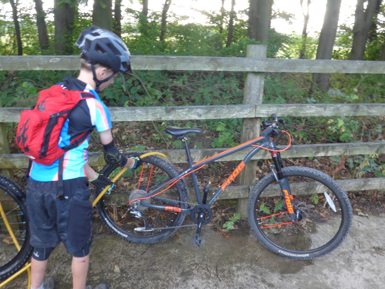 boy cleaning a mountain bike with a hose
