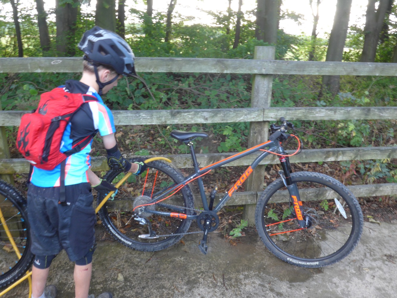 boy cleaning a kids mountain bike with a hose