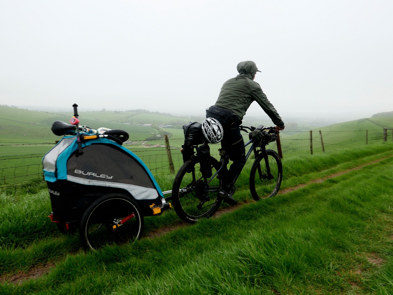 dad bikepacking on a foggy day with his trailer