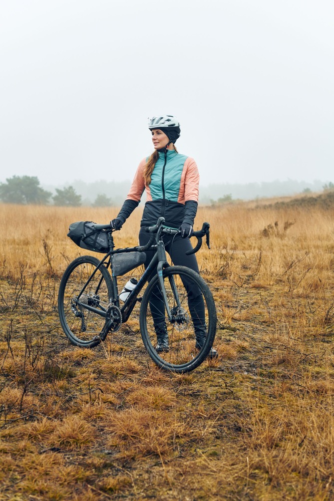 a woman with a gravel bike with bikepacking bags