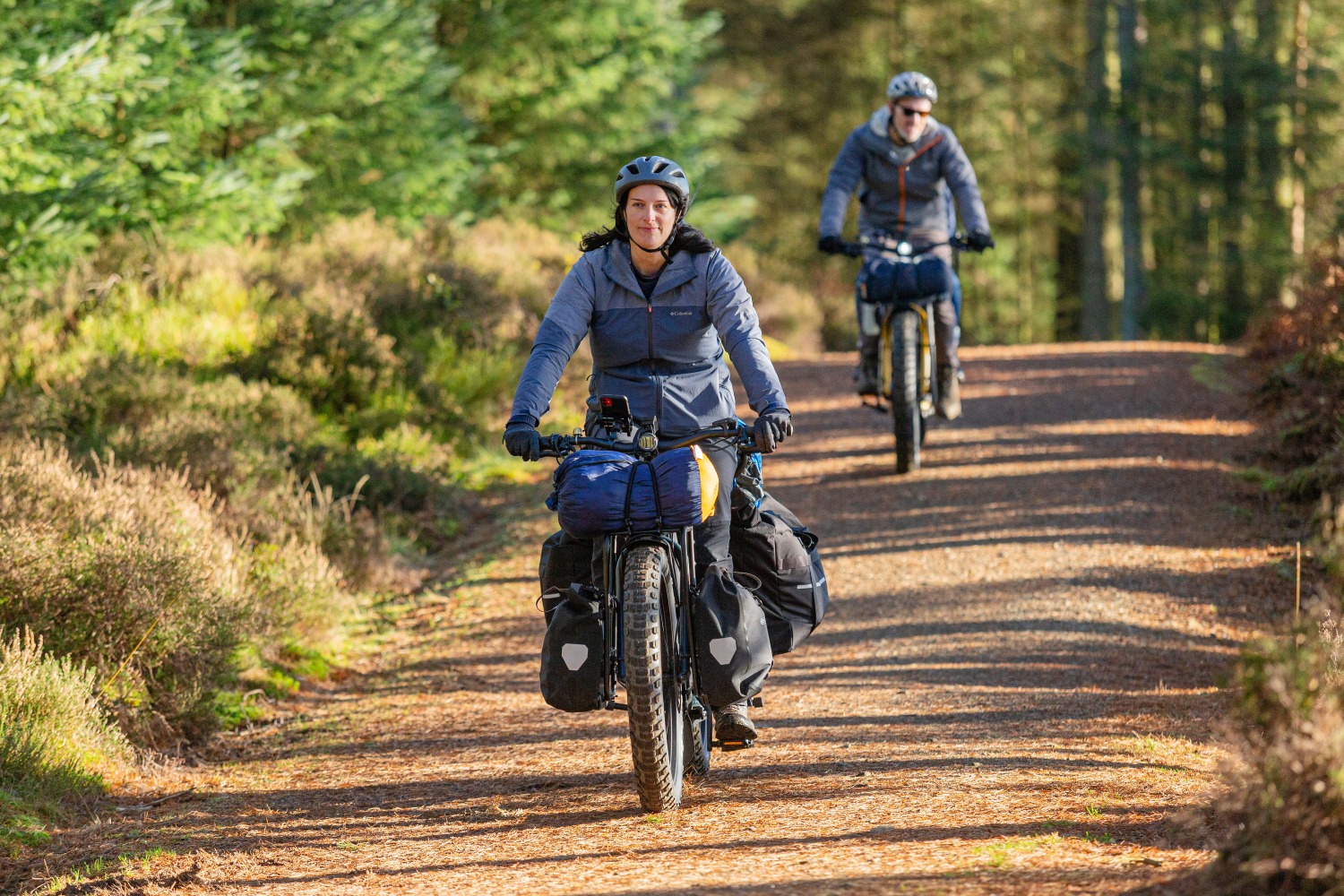 orox long tail cargo bike, a woman riding with lots of bags through the forest