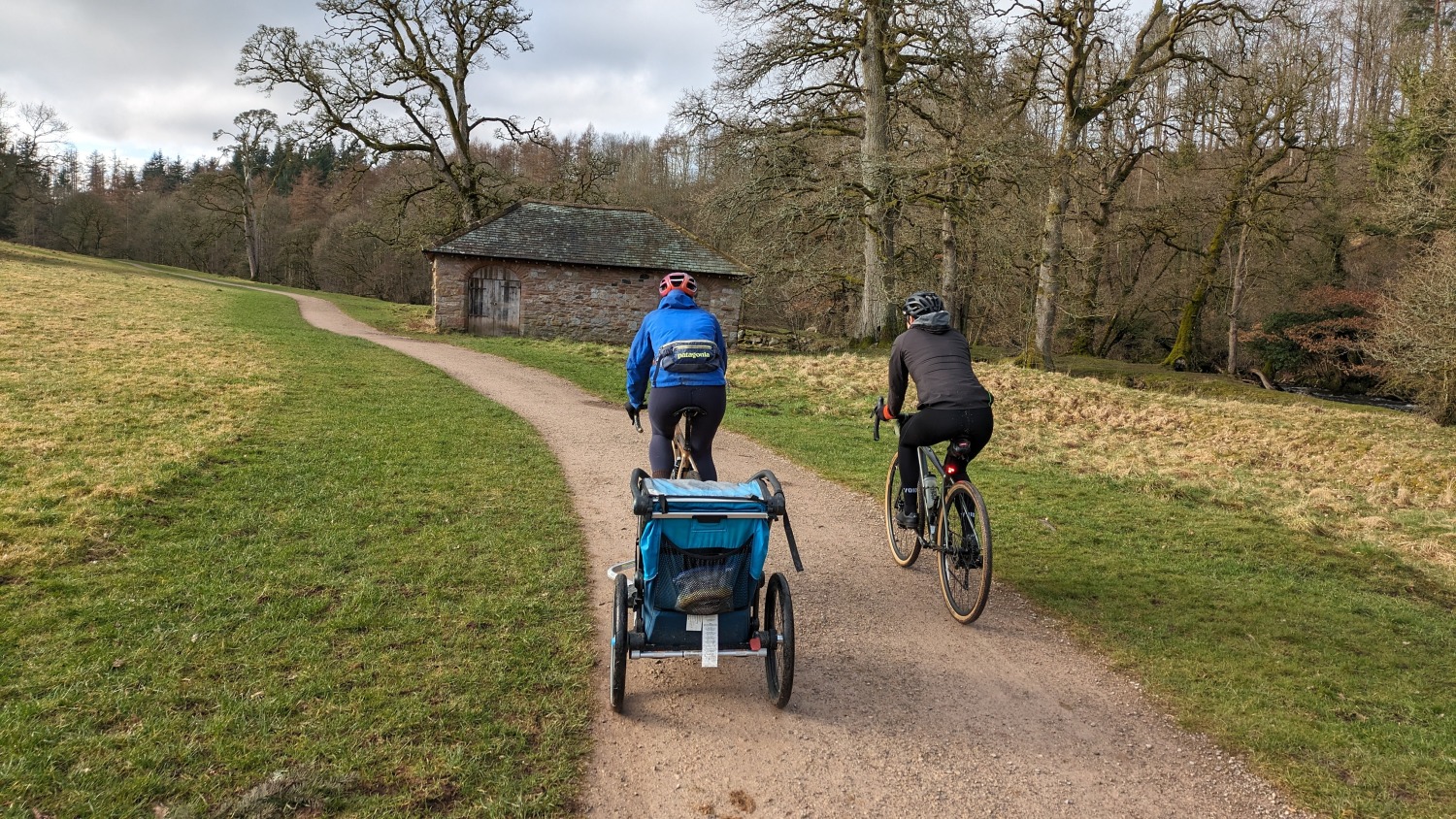 bike ride on a smooth gravel track, two women on bikes and a kids trailer