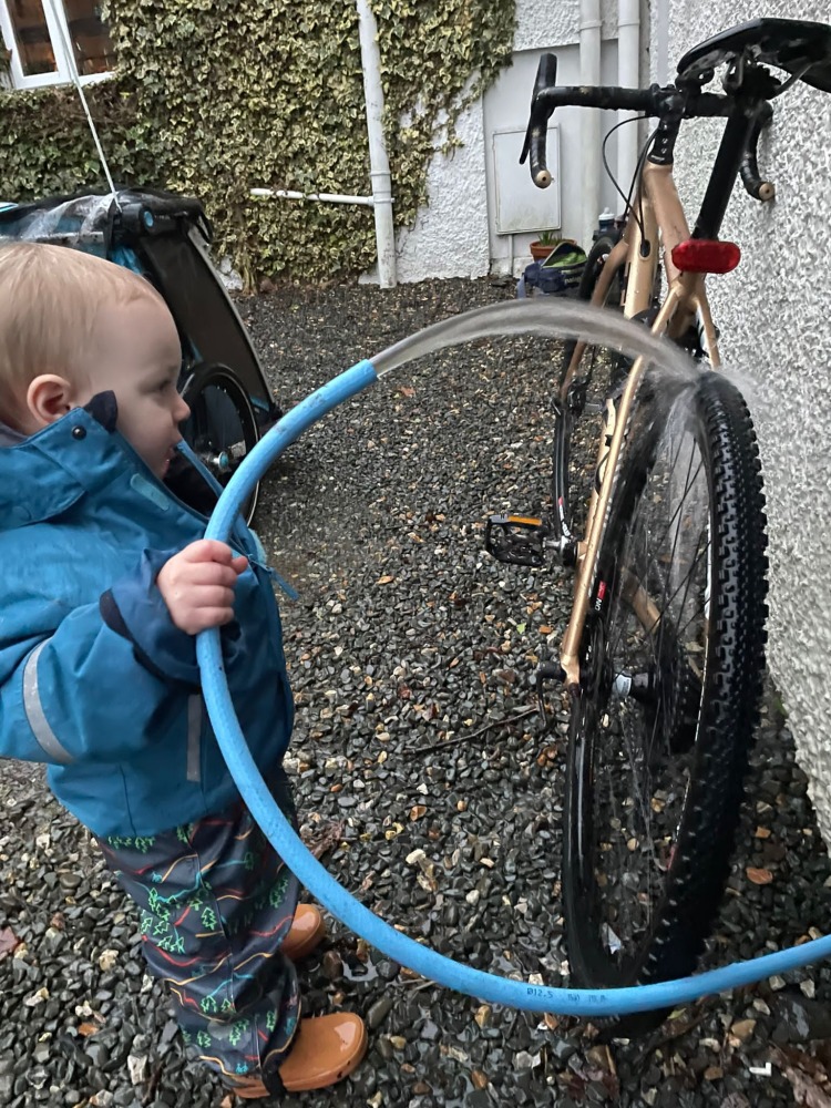 toddler hosing down a bike