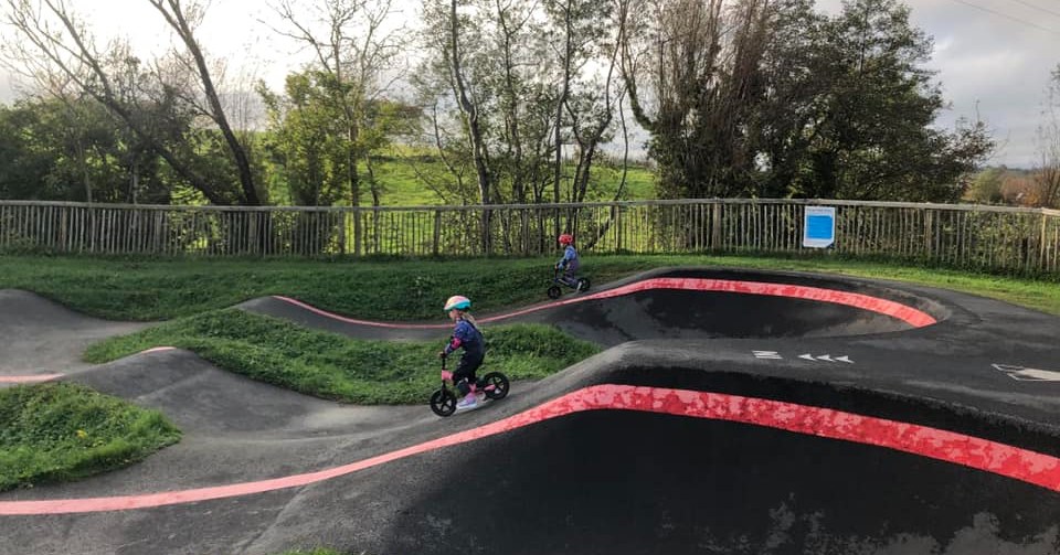 two children riding a pump track