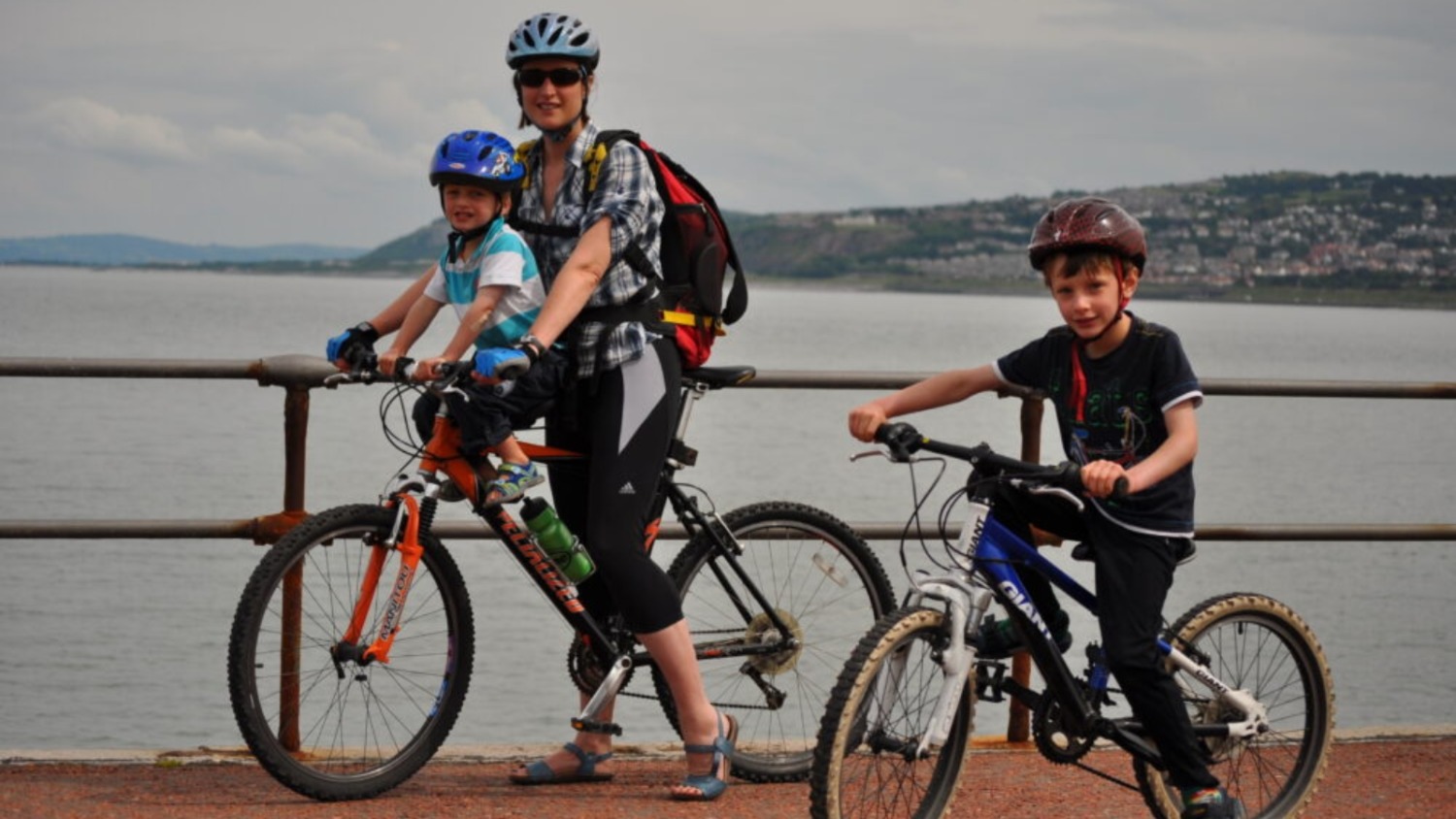 A group shot of Karen Gee, with her youngest son in a front seat, and her eldest on his own bike