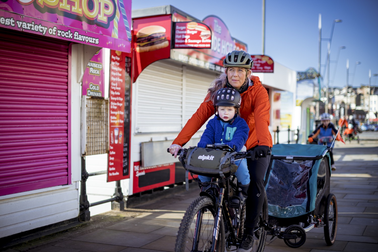 mum and son cycle along a sea side prom