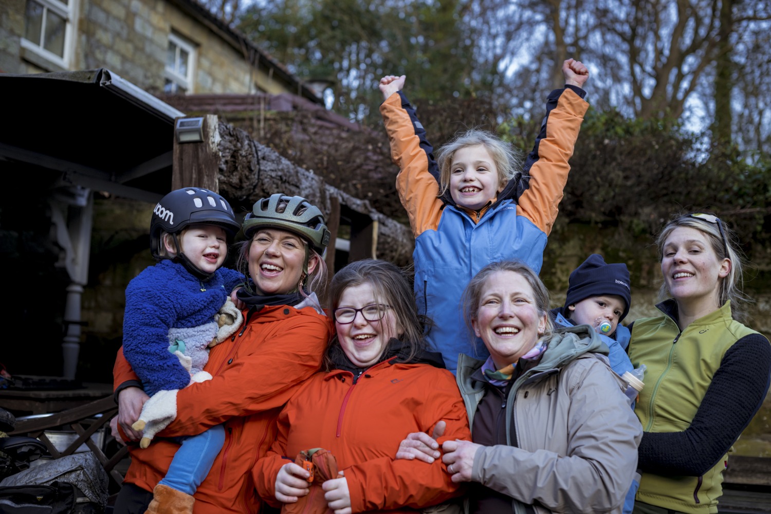 8 joyful cyclists in colorful coats enjoying a bike ride