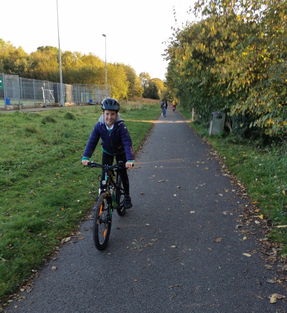 cycling to school- a girl riding in her school uniform