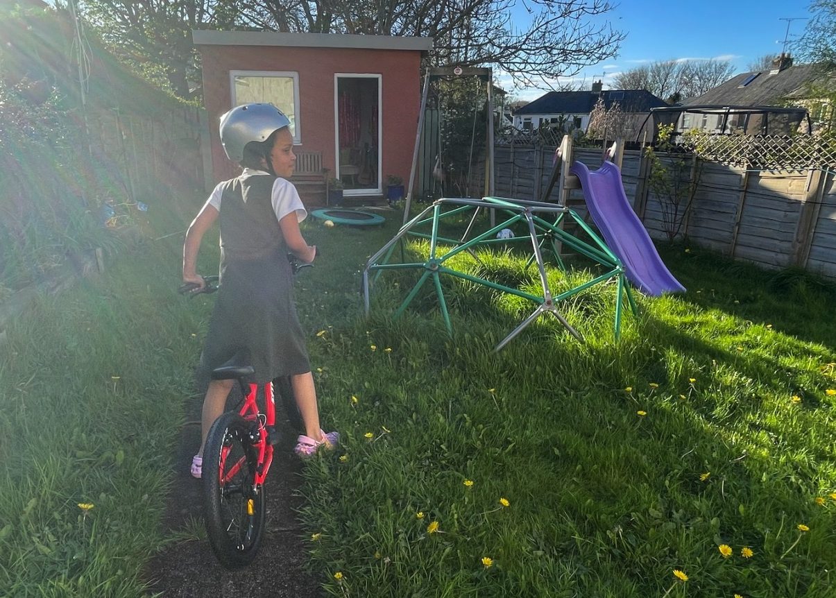Young girl riding the Kidvelo Rookie 18 bike in her garden