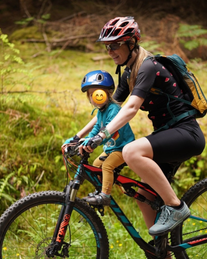 Kids Ride Shotgun seat review, side on photo of a mum and daughter riding on an off road trail