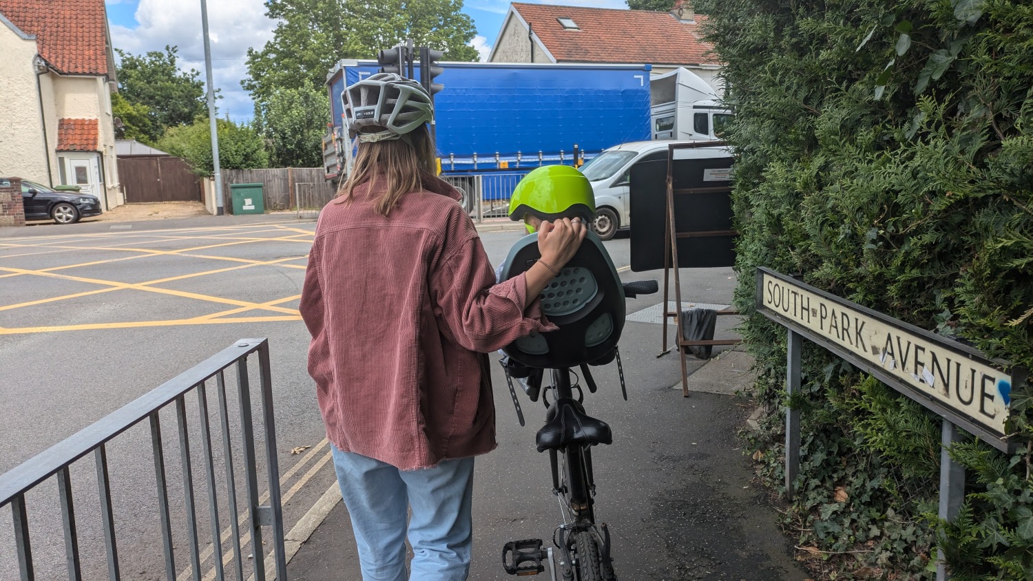 Parent and child on bike at junction Parent with adult bike with front seat on it with toddler in it