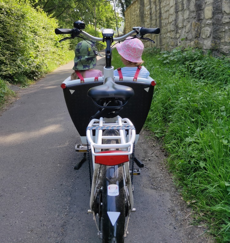 Urban Arrow Family cargo bike with two children sitting on bench