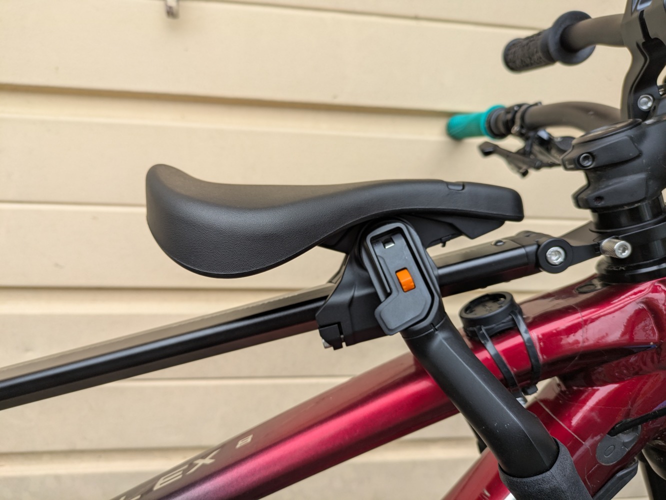 A Kids Ride Shotgun Pro Evo seat, in toddler mode mounted to a red trek MTB- a close up of the black, sleek design seat