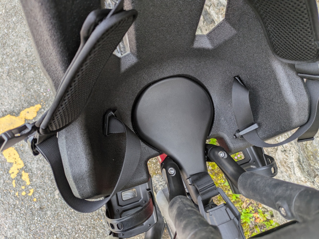 A Kids Ride Shotgun Pro Evo reat mounted to a red mountain bike leant against a stone wall- close up of the saddle