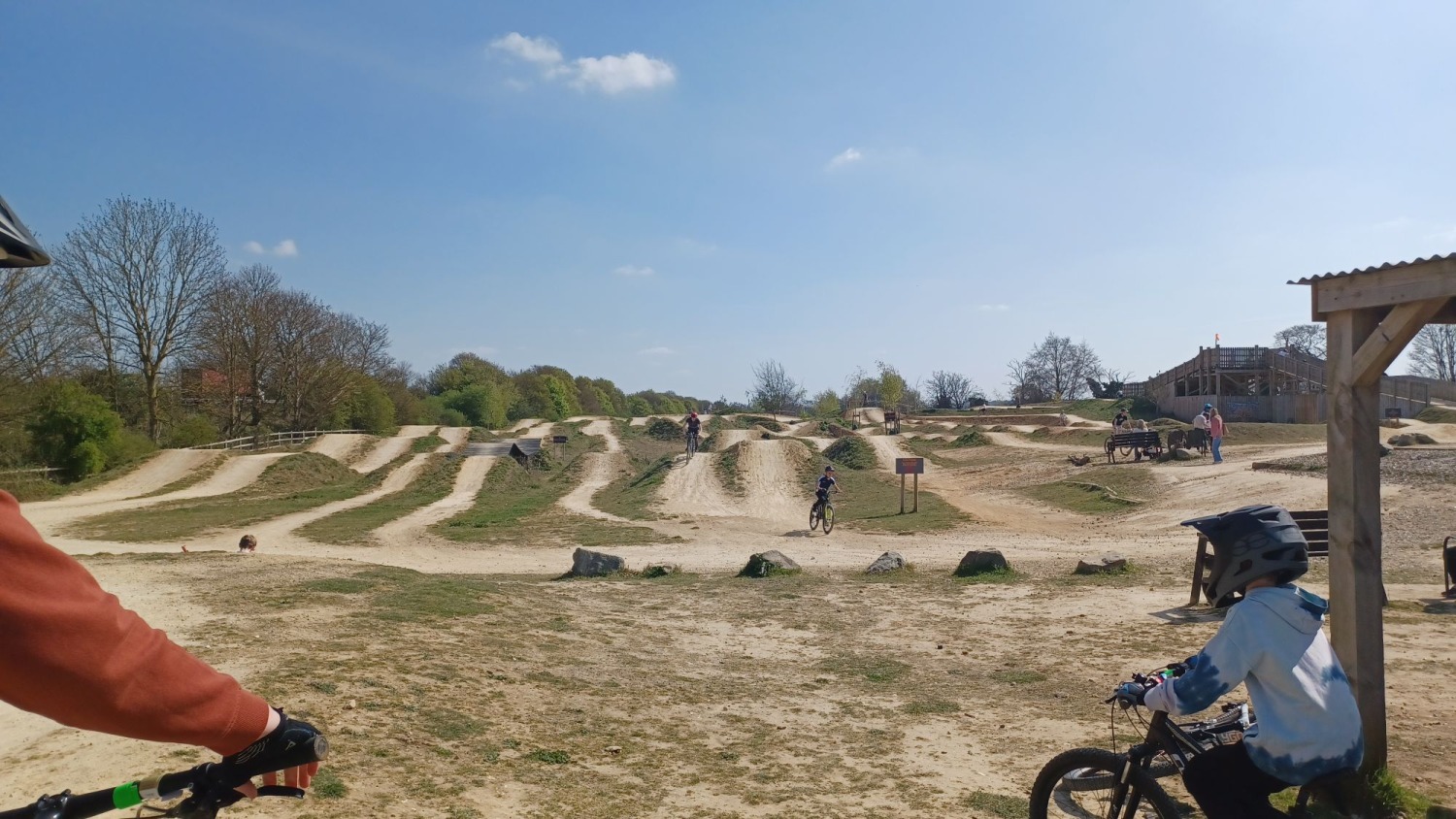 Ruth Preece – Phoenix 2 A huge dirt track pump track, with a couple of kids in full face helmets in the foreground