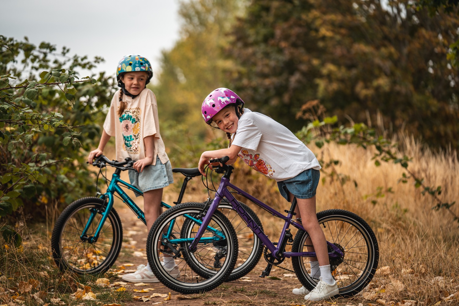 HERO-129 Gareth Evans Two little girls standing over hornit bikes with bushes behind them