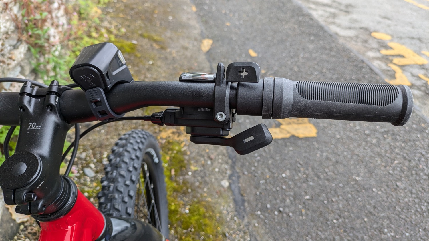 Red 20 inch BTWIN EXPL 900r leant against a wall- close up of the gear shifter