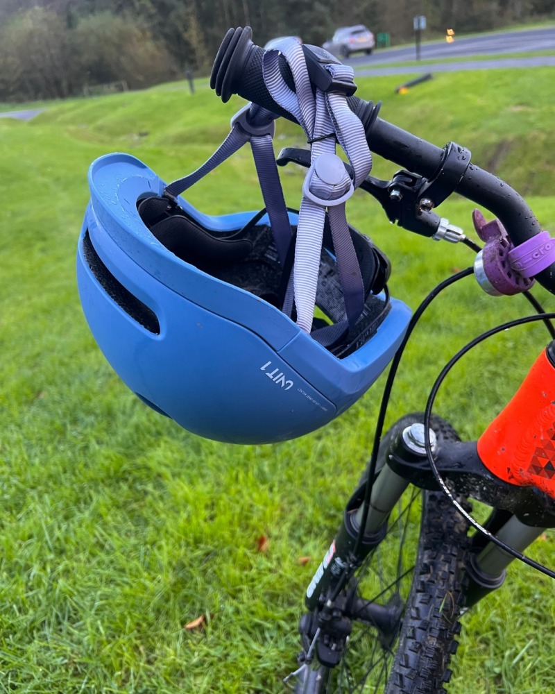 a blue SPARKY helmet hanging on a bike