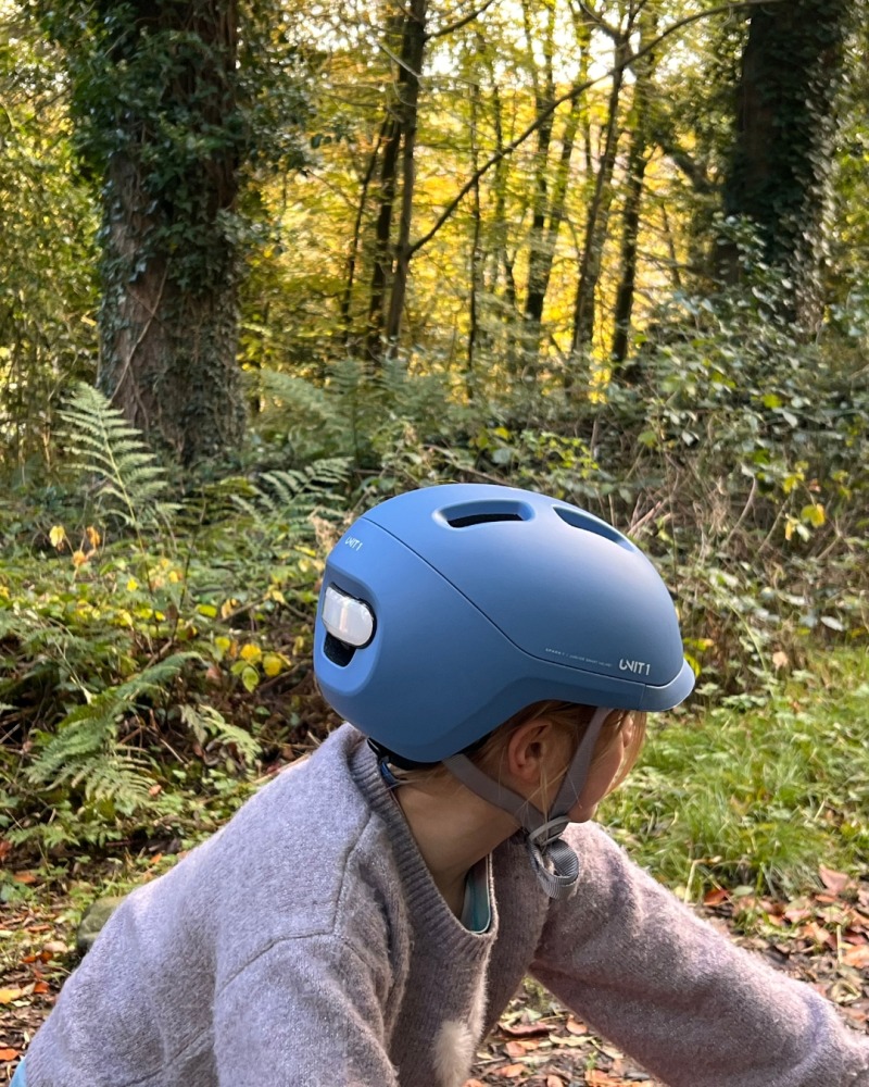 A girl wearing a blue SPARKY helmet- riding her orange mountain bike