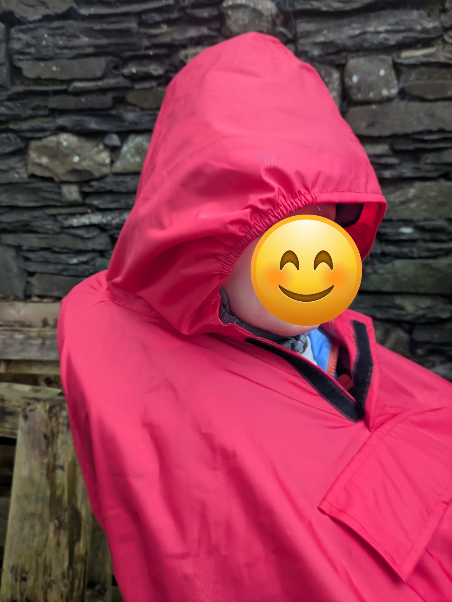 a little boy on a rear bike seat in his red Hamax Bike Seat Rain Poncho