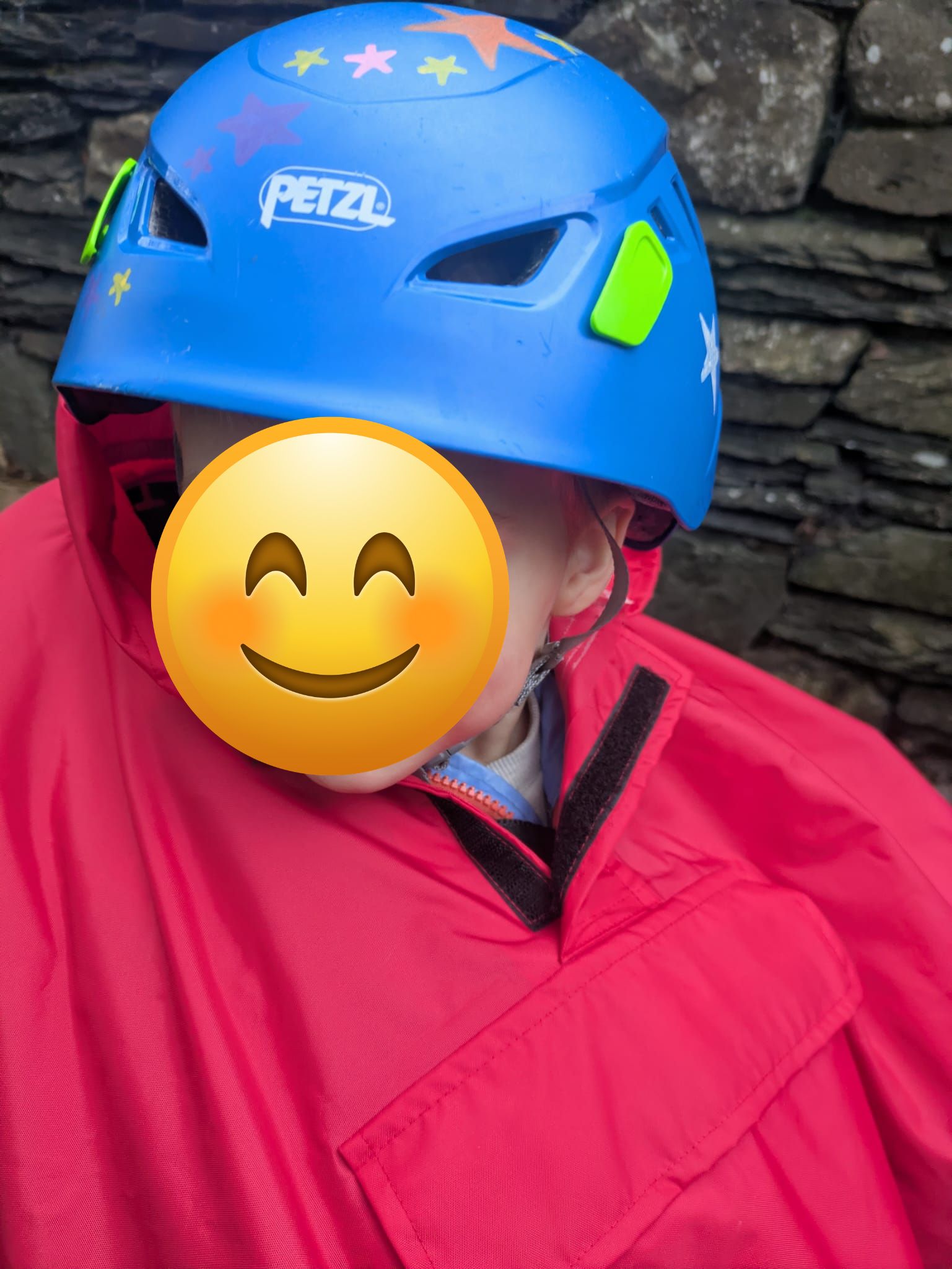 a little boy on a rear bike seat in his red Hamax Bike Seat Rain Poncho