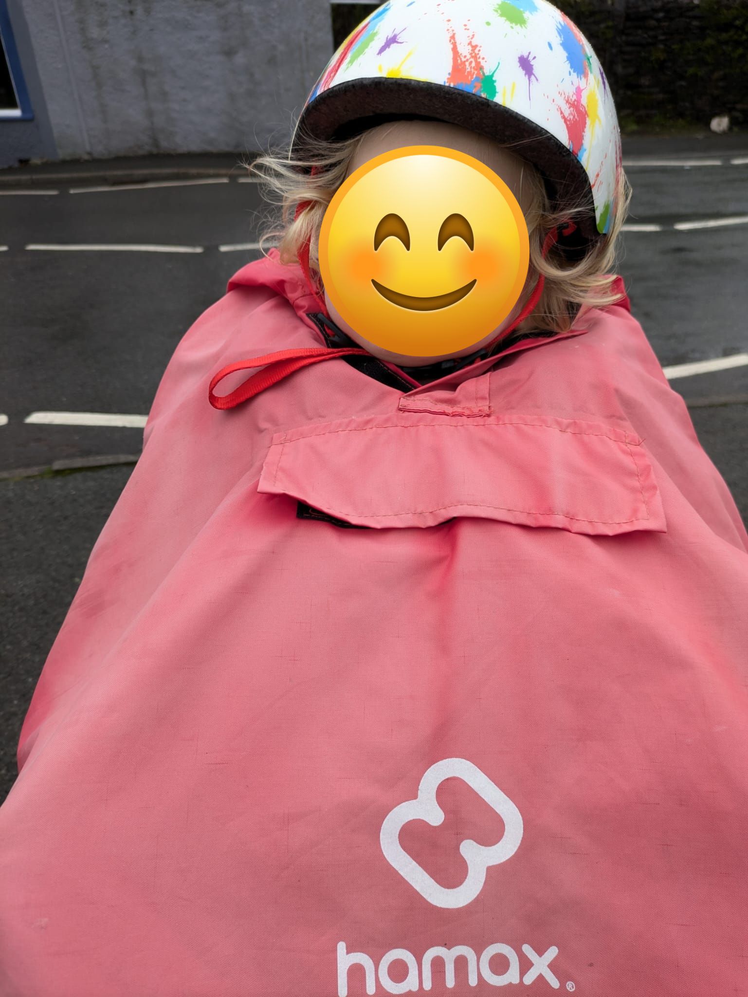 a little boy on a rear bike seat in his red Hamax Bike Seat Rain Poncho sleeping
