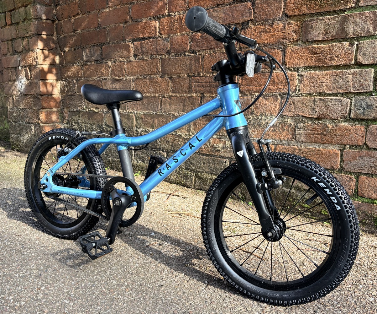 Photo of Rascal Bikes kids 14 inch blue first bike up against a brick wall