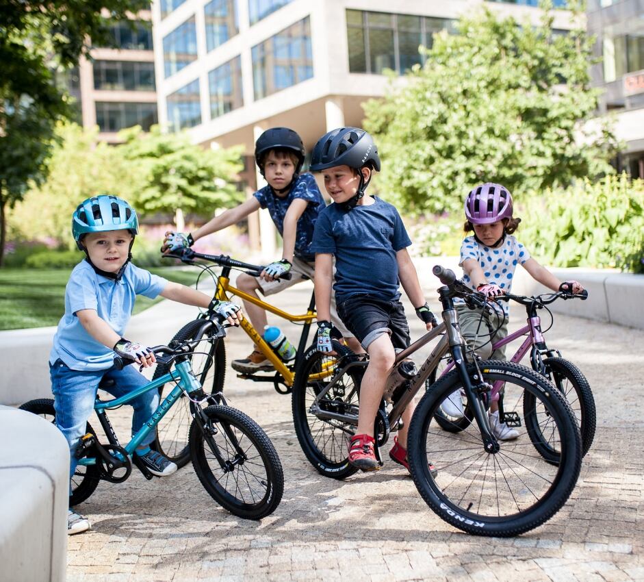 Photo of four children riding Rascal Kids Bikes and wearing Rascal helmets