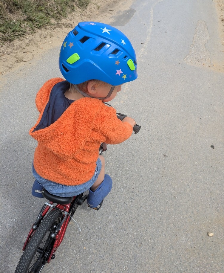Hornit HERO 14 kids bike being ridden on a paved sandy path to the beach