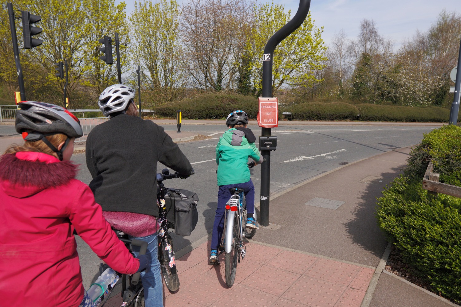 Geoff and Kate riding an old turquoise tourer tandem towing a yellow and blue double child trailer. One child is just visible through the mesh front of the trailer.