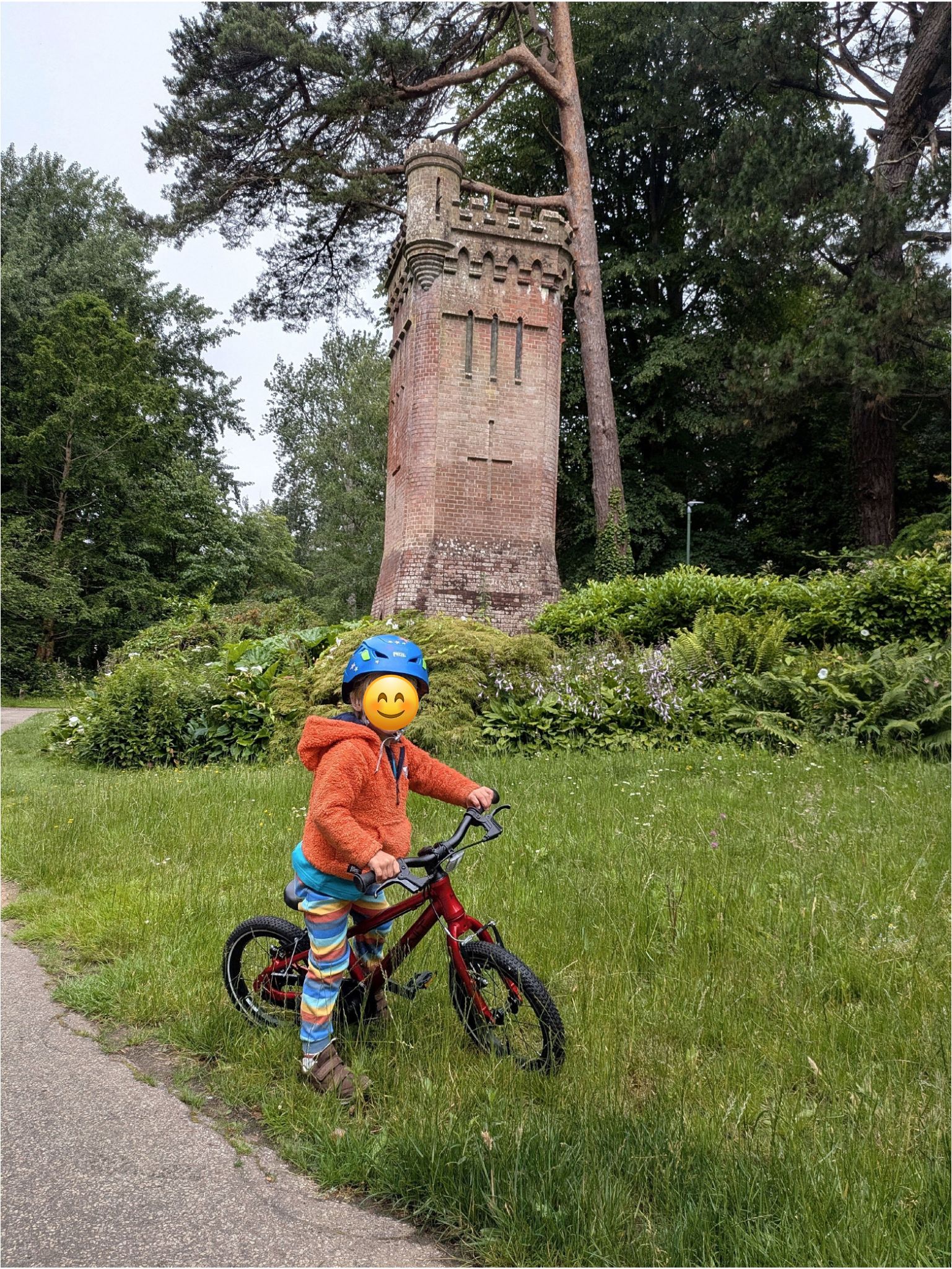 Hornit HERO 14 kids bike being ridden on grass beside a paved path 