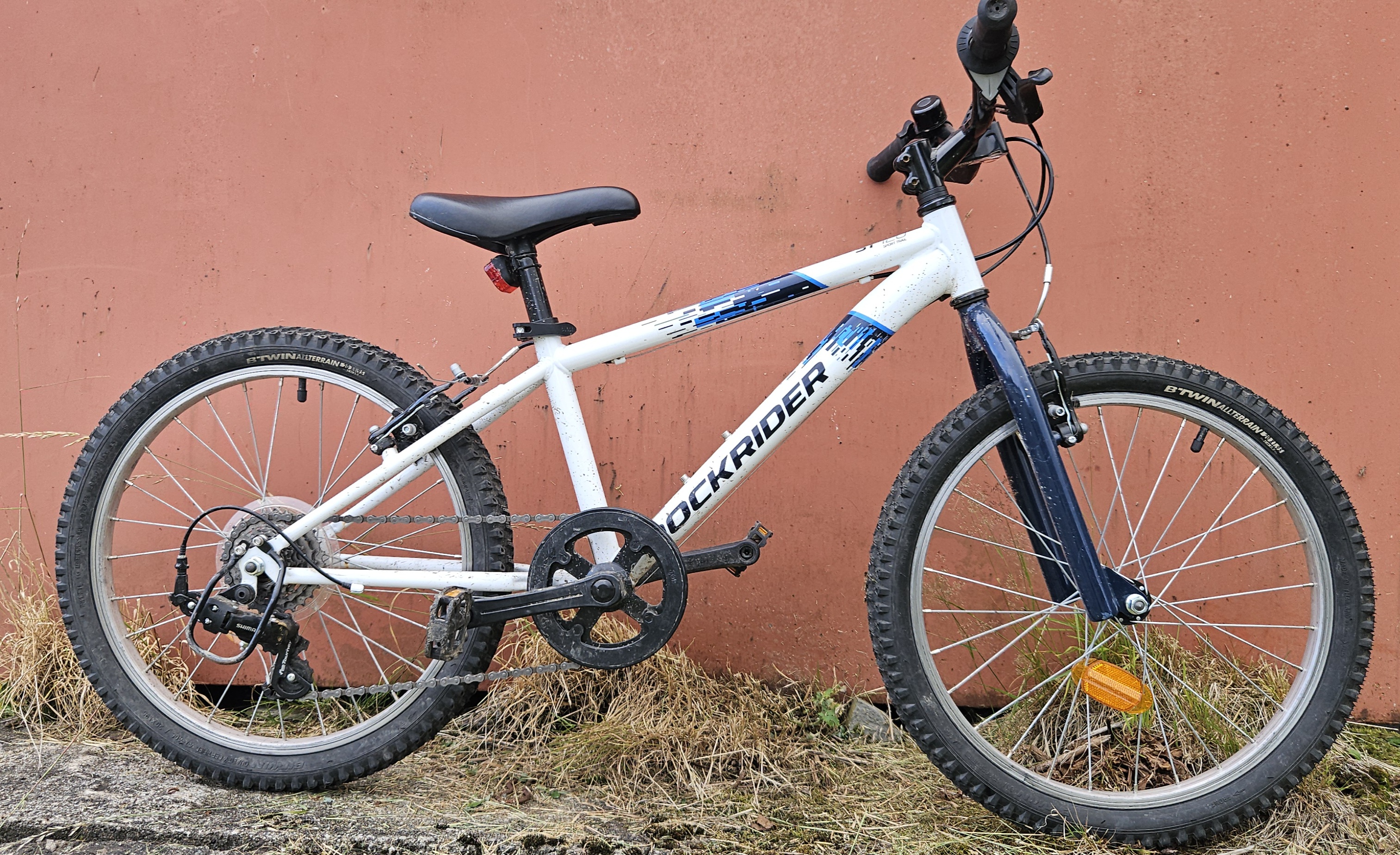 Rockrider 120 MTB Expl kids bike leant against a wall 