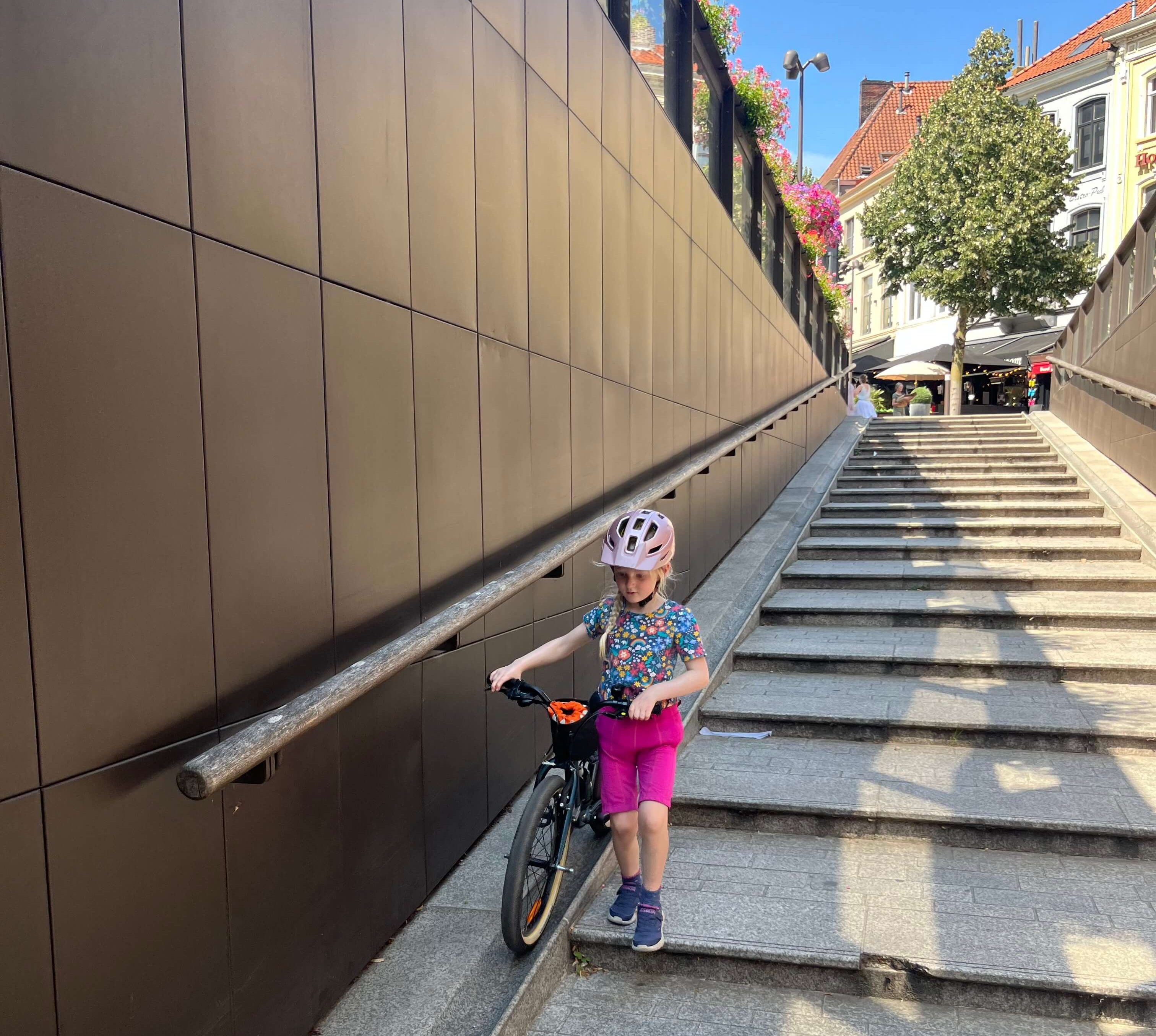 Young girl pushing the Ridgeback Dimension 20 kids bike down a slope with steps