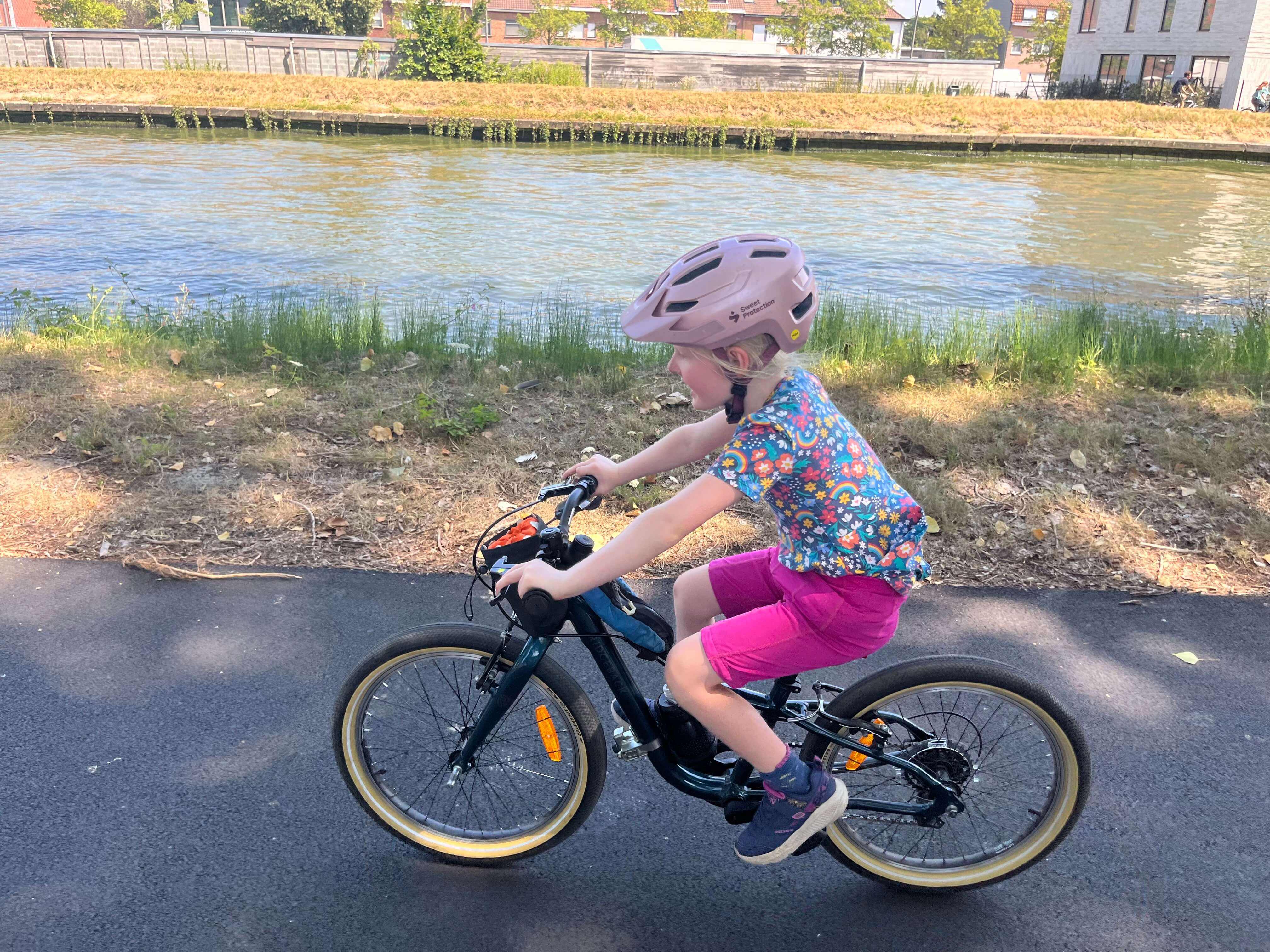 Ridgeback Dimension 20 kids bike being ridden by a young girl beside a river