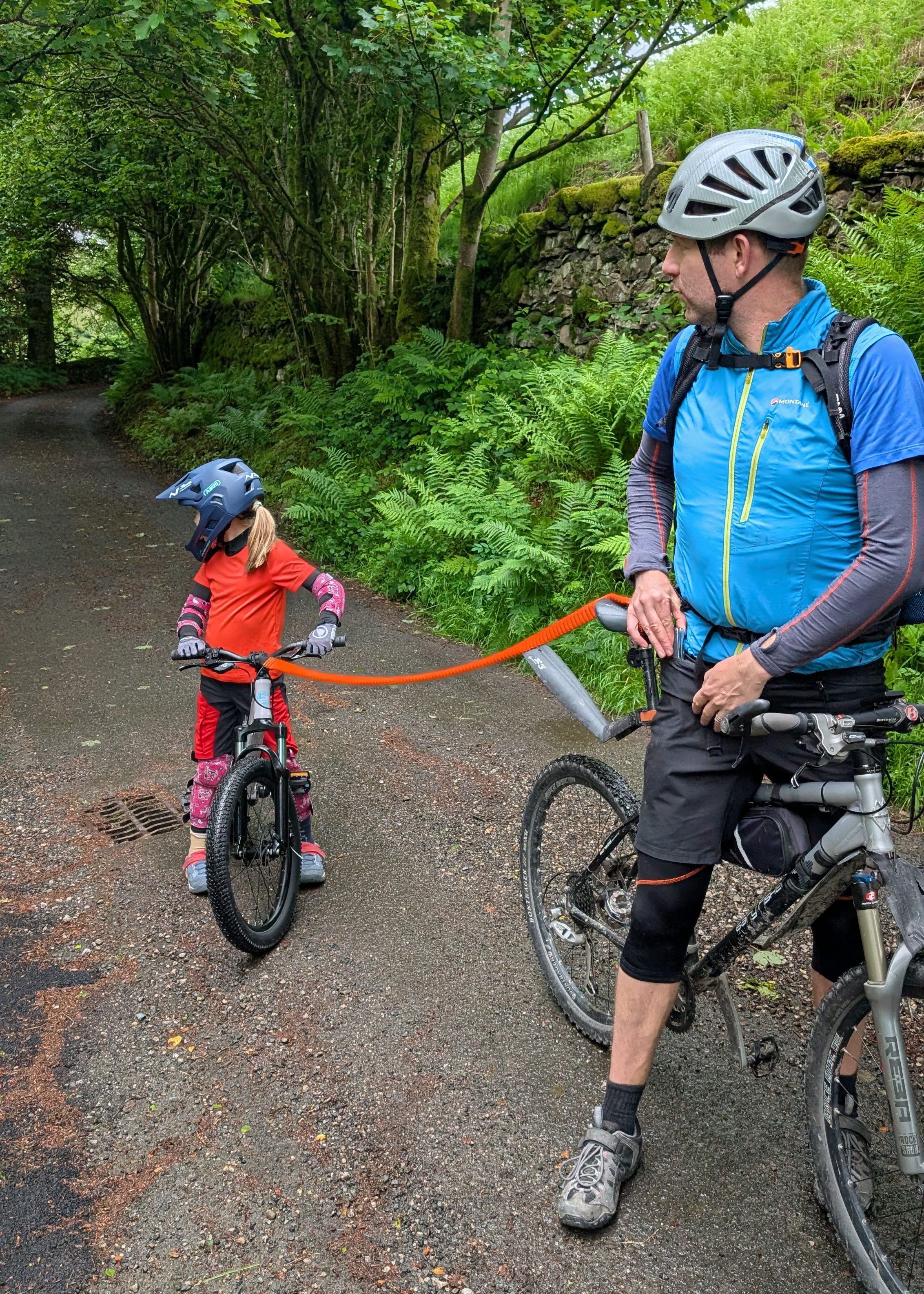 Shyre Eastie 20 kids bike being pulled along by an adult bike in a forest