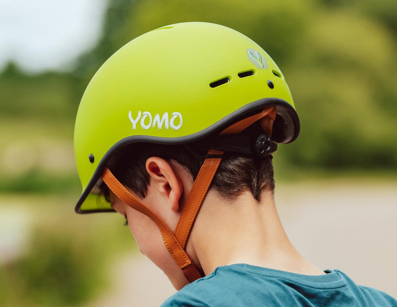 Young boy wearing a green YOMO bike helmet