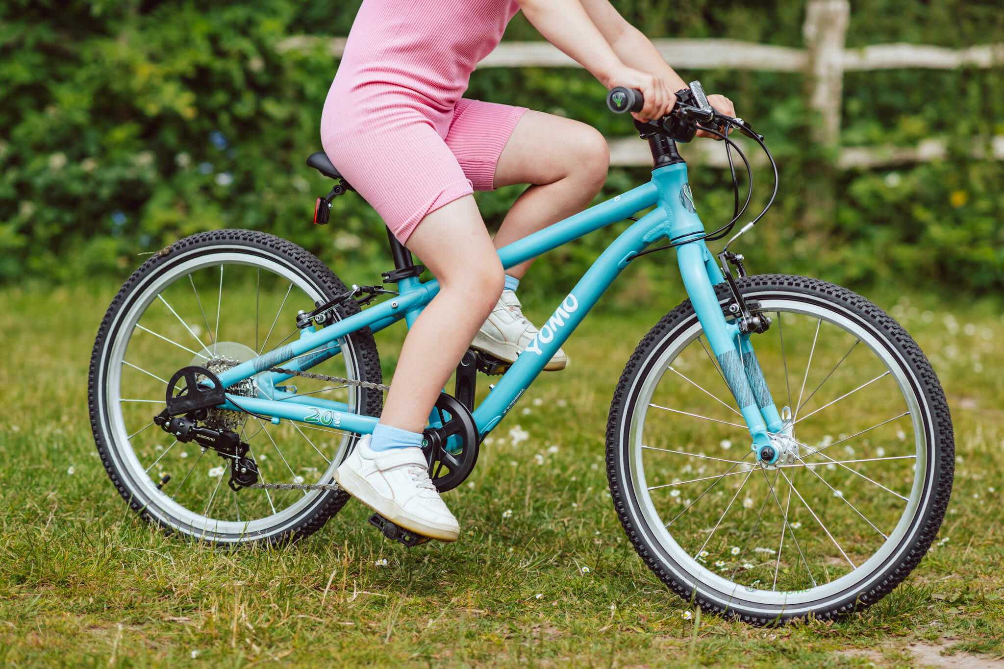 YOMO kids bike in turqouise being ridden by a girl dressed in pink