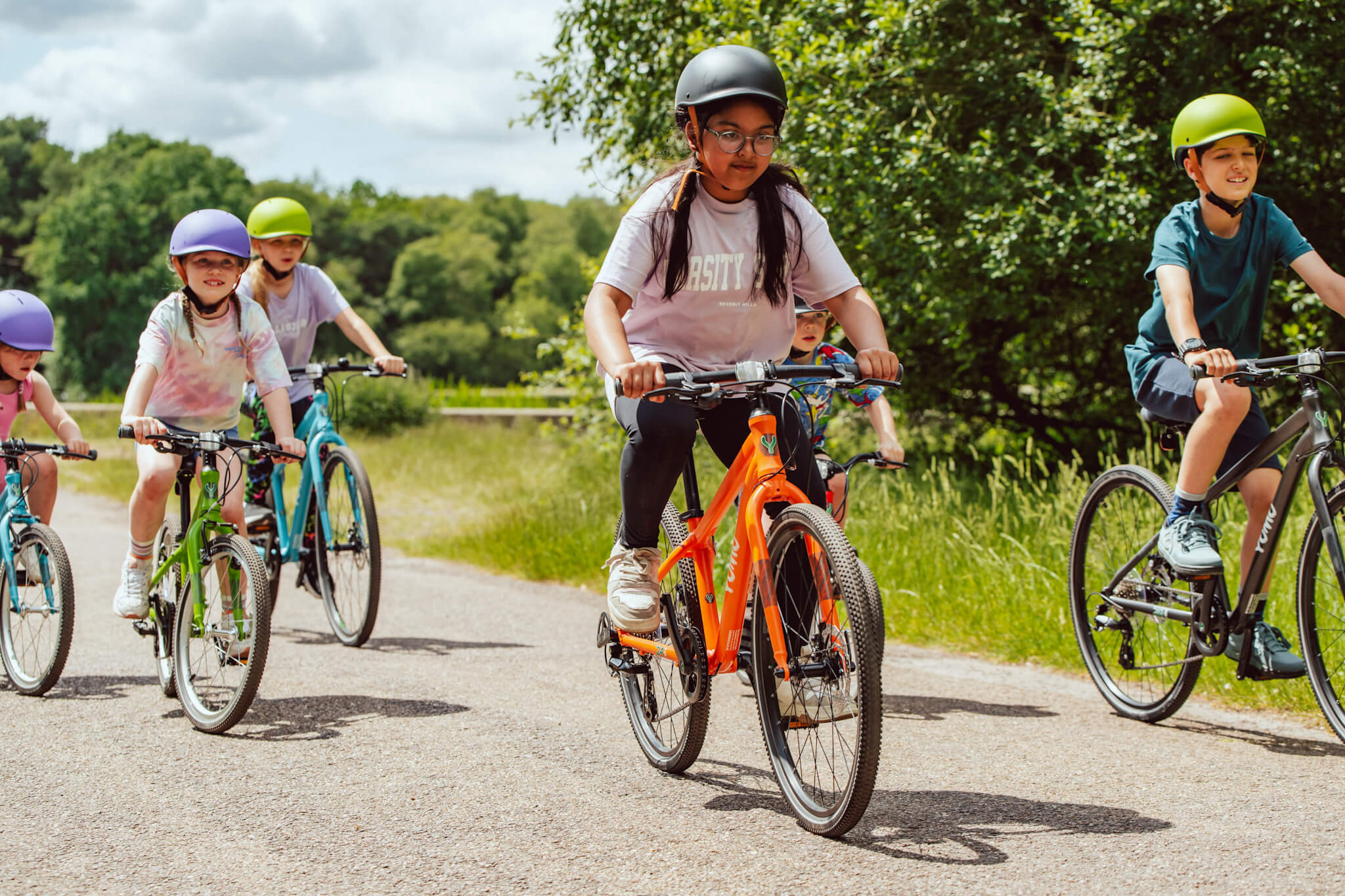 Group of children riding YOMO bikes along a country lane