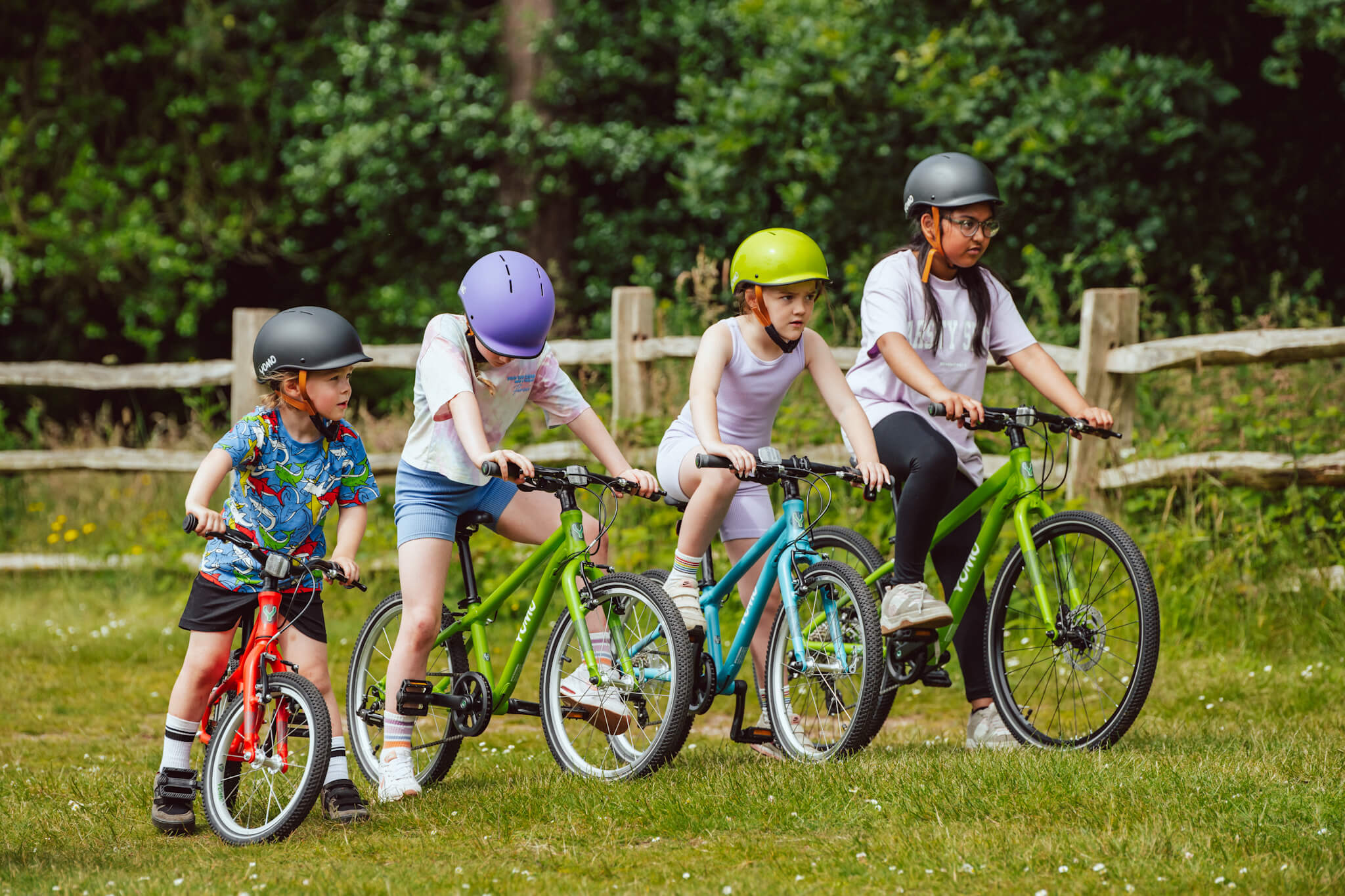 Group of kids with Yomo bikes stood in a line on grass