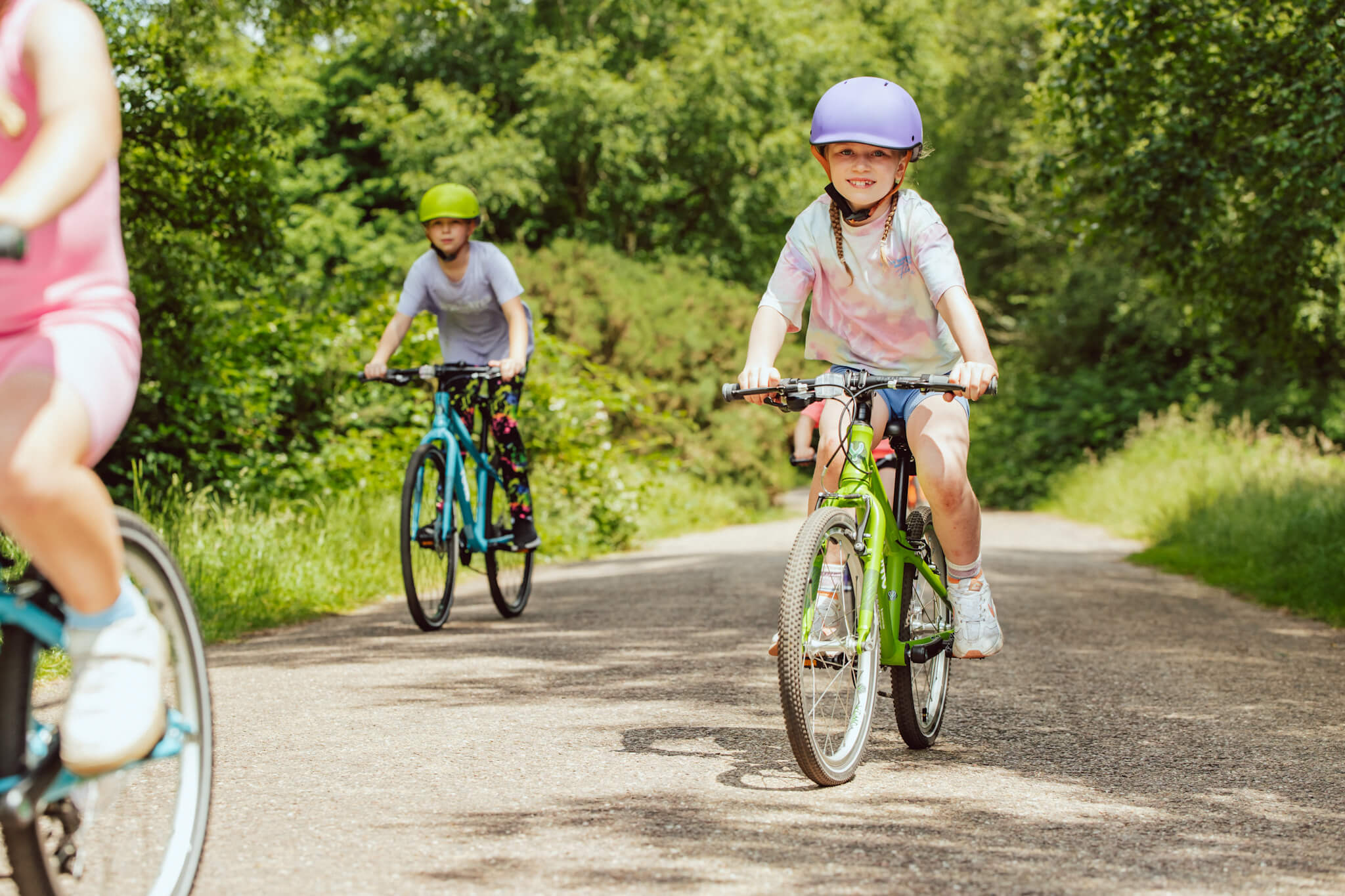 YOMO kids bikes being ridden along a country road by a group of children